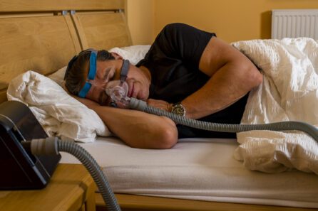 man sleeping with a cpap for sleep apnea machine on