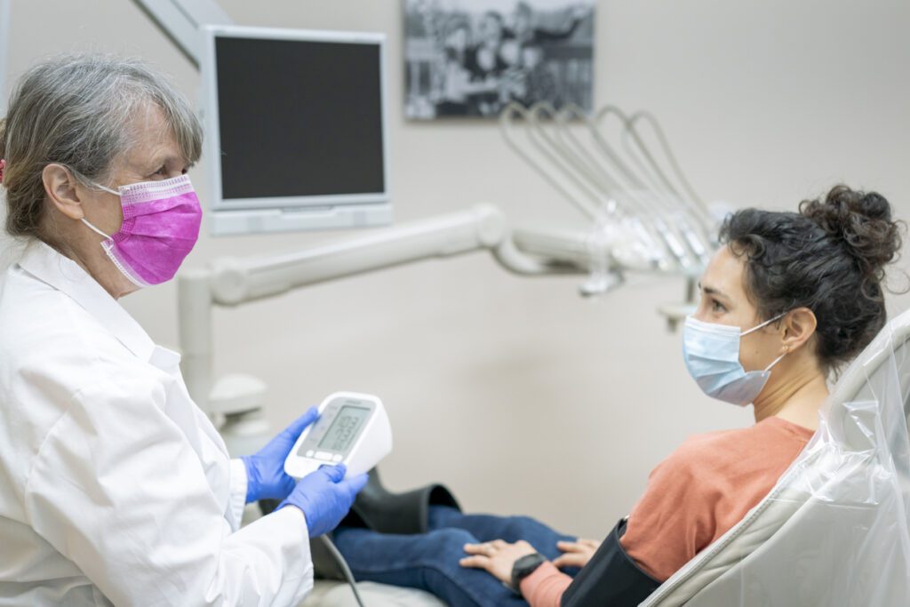 Young Diabetic Patient have blood pressure checked before dental cleaning