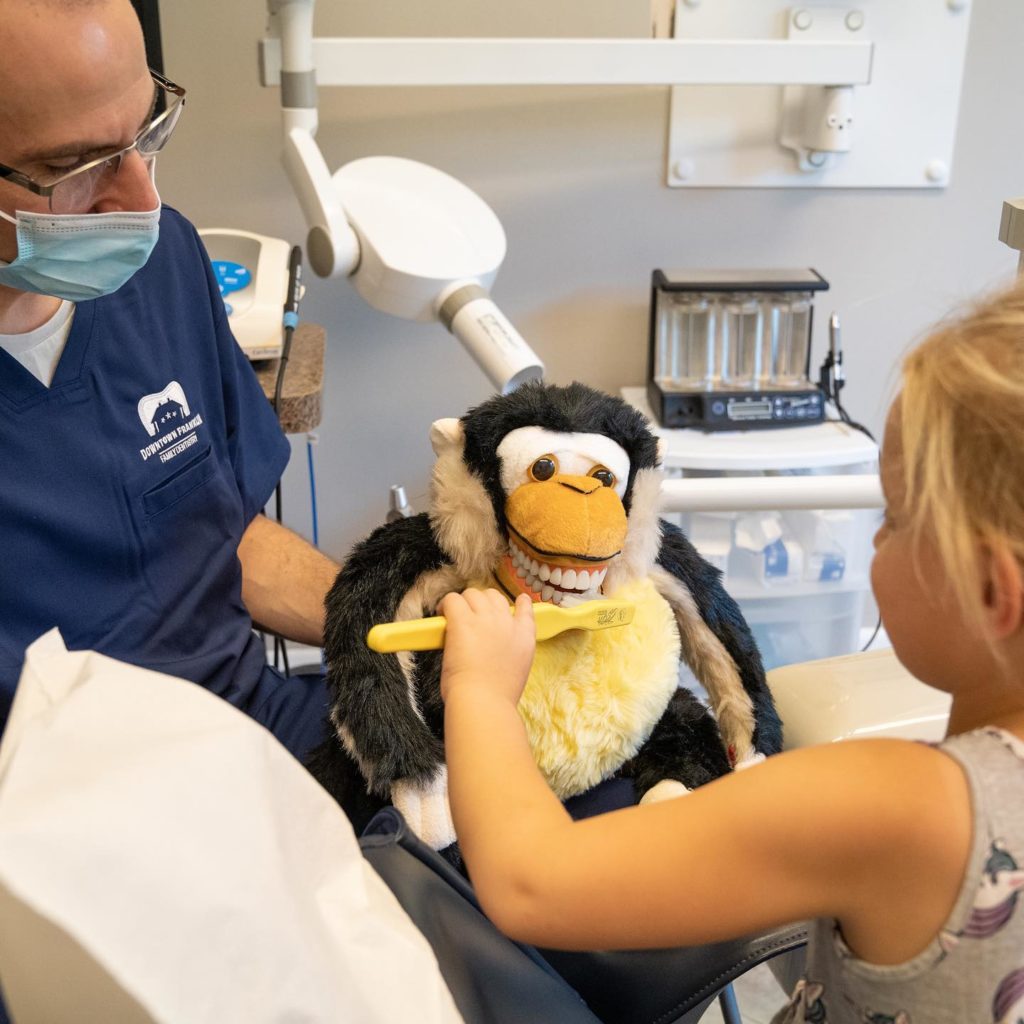 Photo of Dr. Sean Abrams teaching a child how to brush their teath.